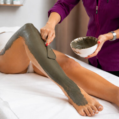 Applicazione di fanghi estetici sulle gambe